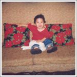 Adi sitting near Christmas pillows